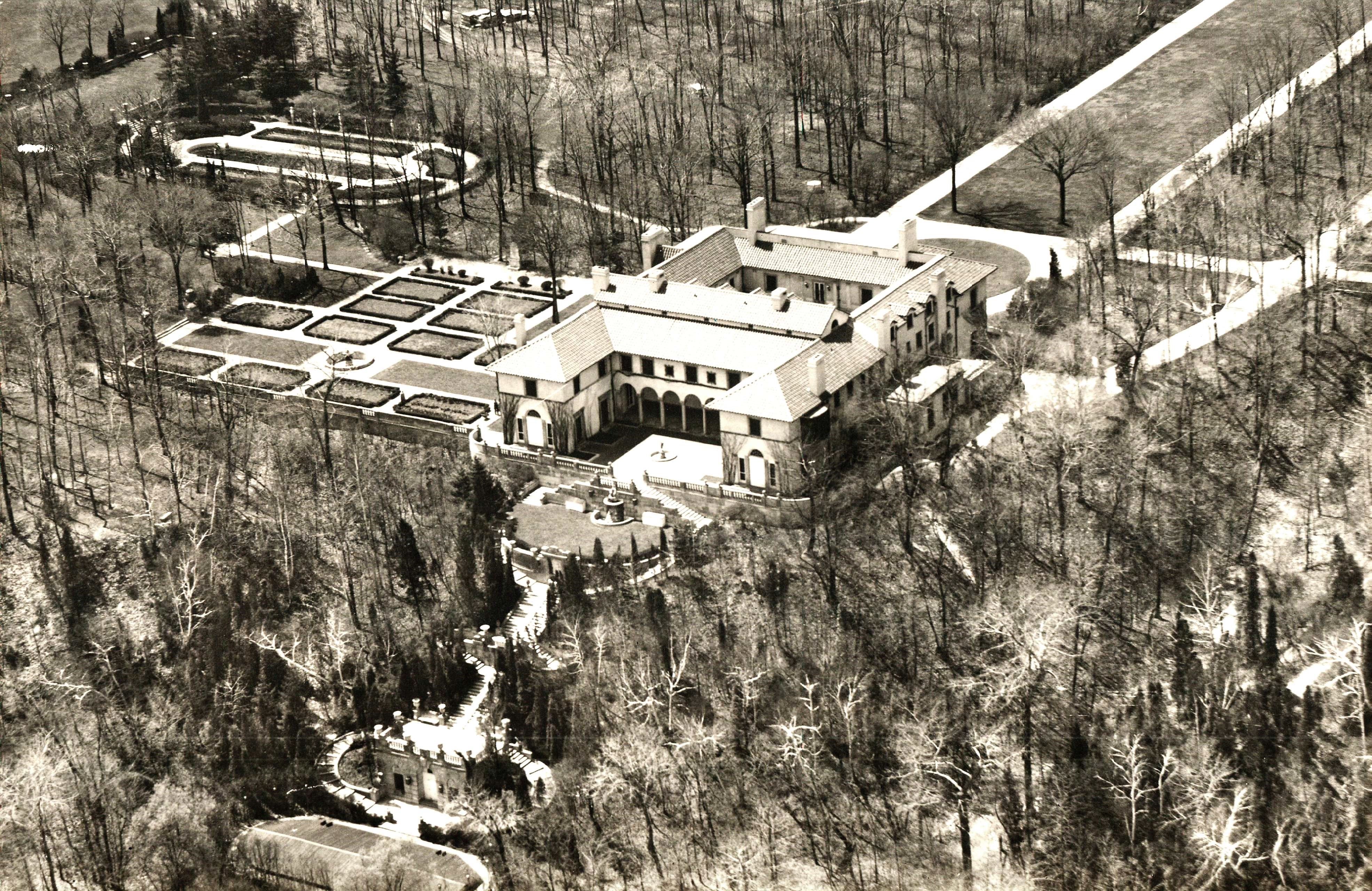 Aerial view of Villa Turicum estate. Sunken garden and lily pool upper left, formal gardens and fountain left of the house and full view of the stairway and watercourse down to the pool at the edge of the lake. Photograph by Chicago Aerial Survey Company.