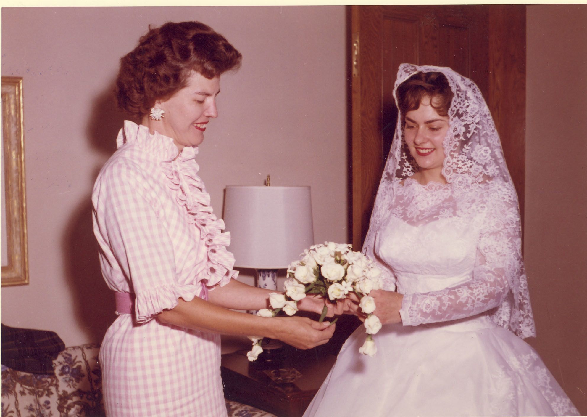 Helping a bride put the finishing touches on her ensemble, 1962.